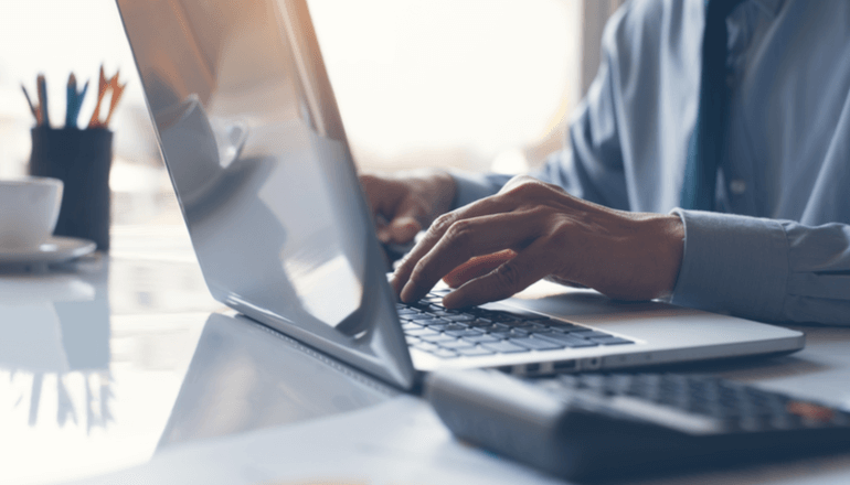 Business professional typing on laptop keyboard